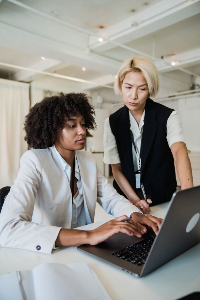 Mentor guiding an intern at a laptop