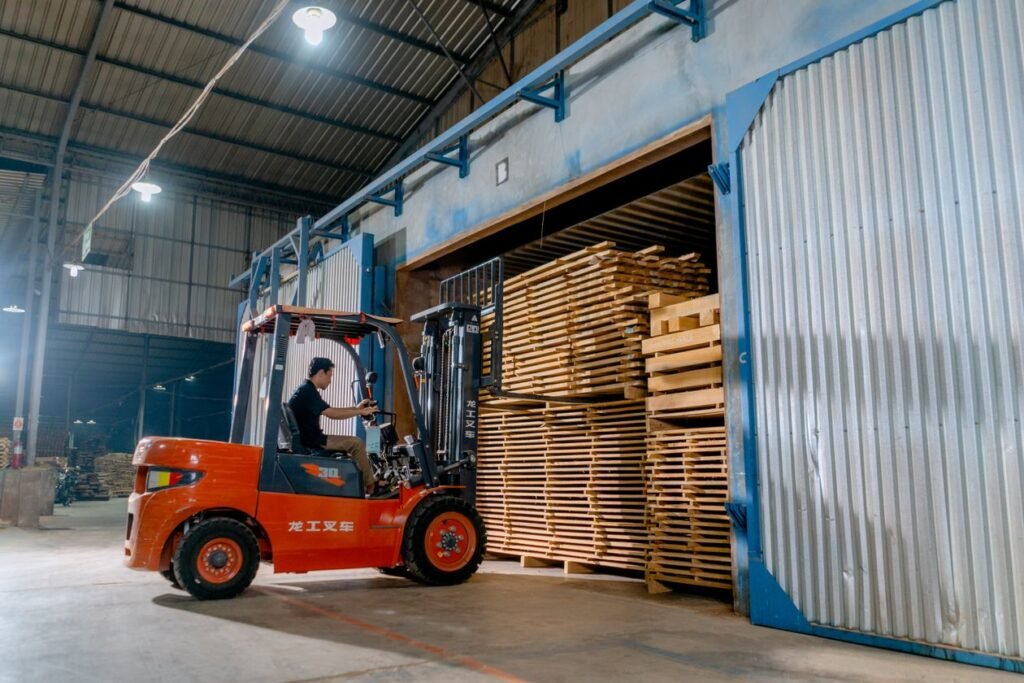 Worker driving a forklift loaded with pallets in a warehouse