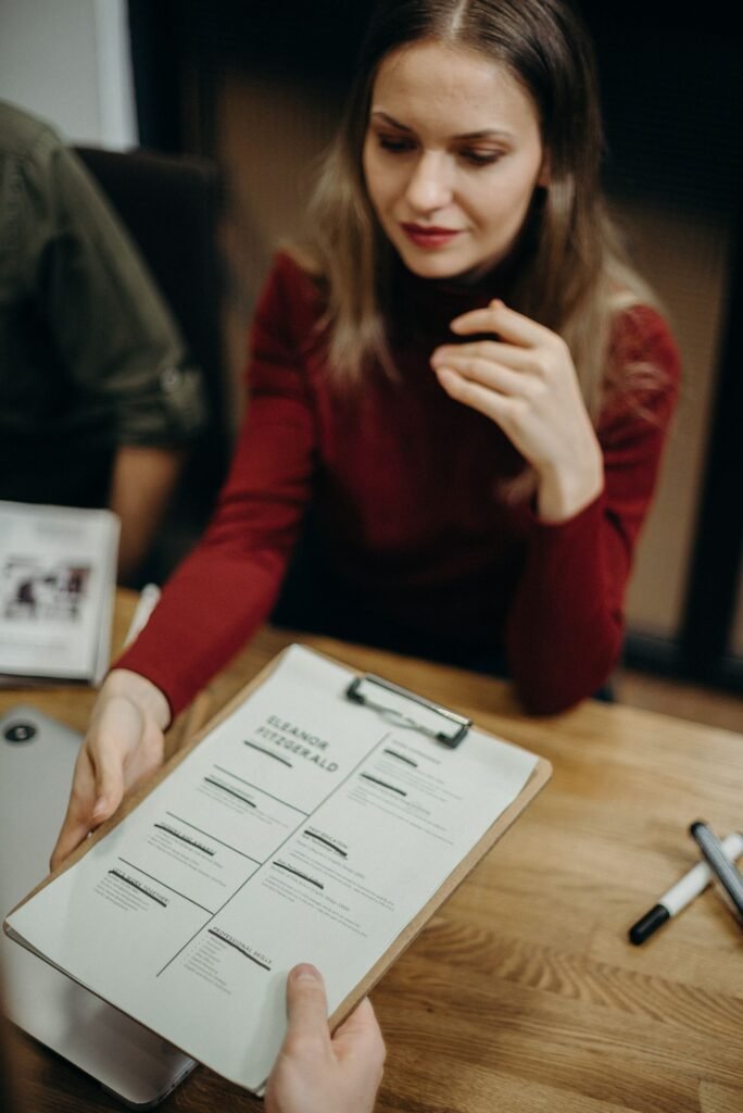 Interviewer reviewing a resume on a clipboard