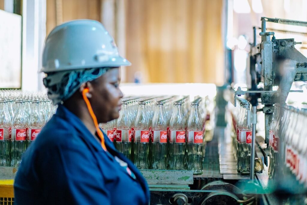 Factory worker in a hard hat monitoring a production line