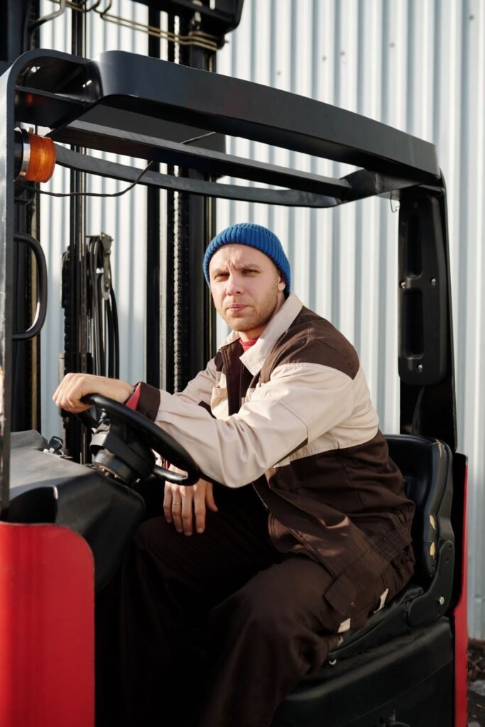 Forklift operator in a warehouse wearing a beanie