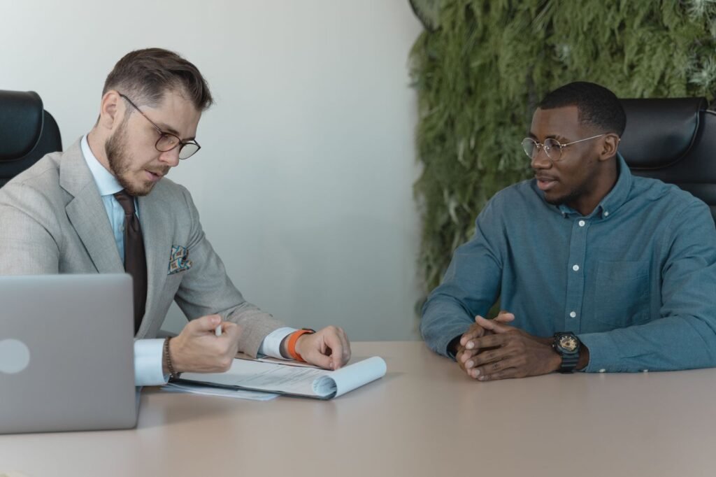 Two men reviewing documents across a desk