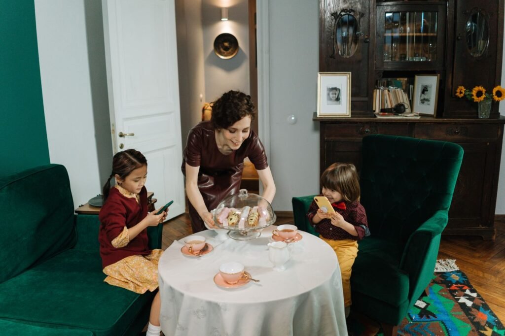 Caregiver serving children at a table in a home