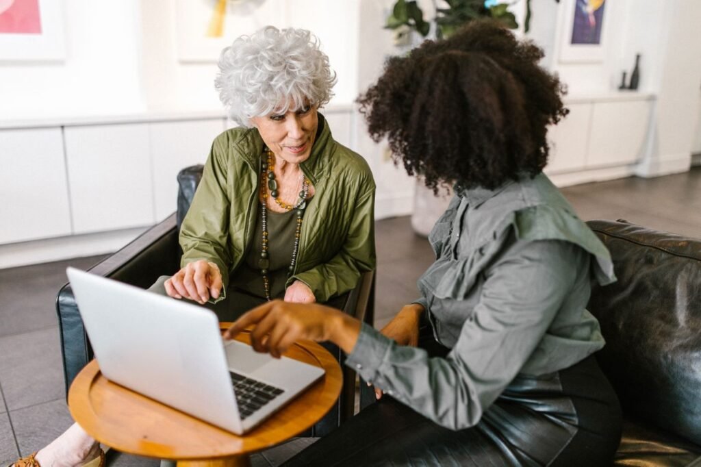 Two women reviewing a job message on a laptop