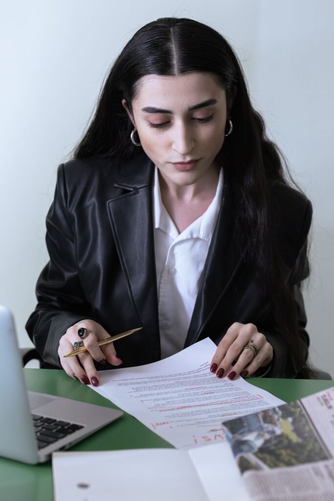 Professional reviewing a document next to a laptop