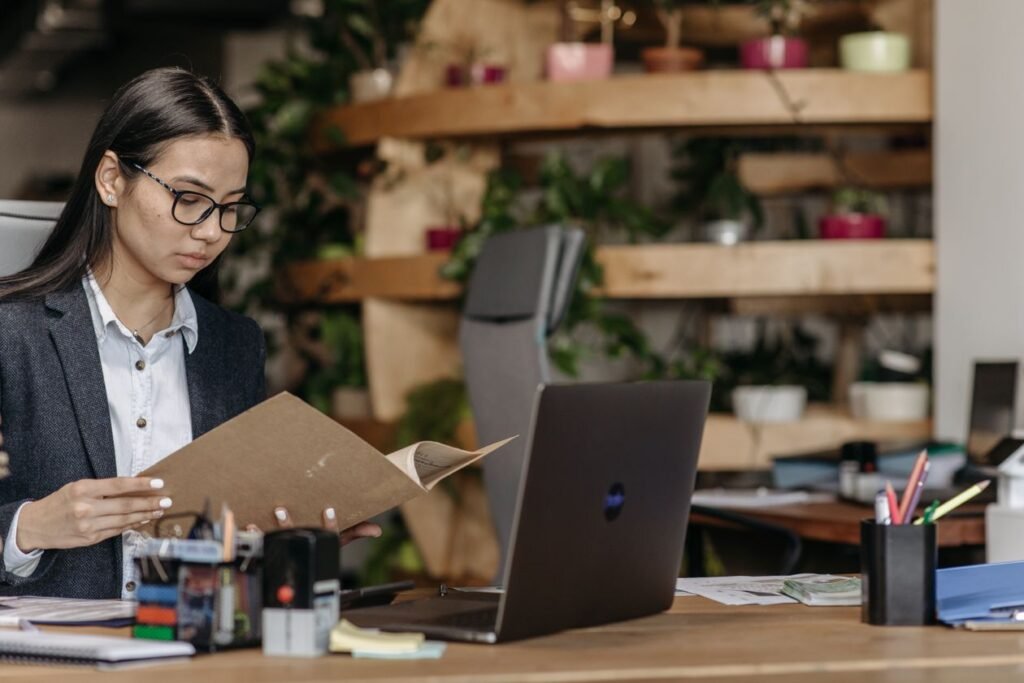 Accountant reviewing documents at a laptop in an office