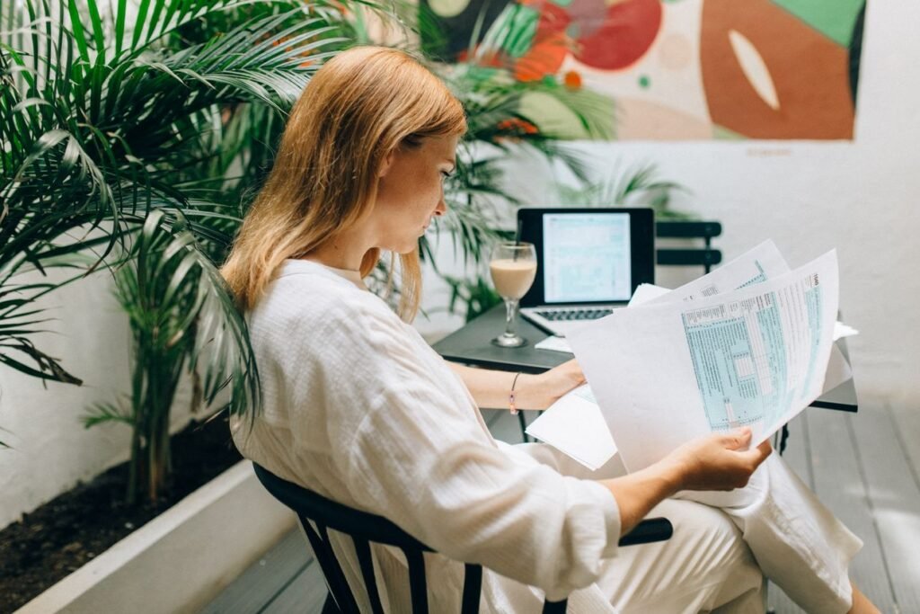 Accountant reviewing financial documents next to a laptop